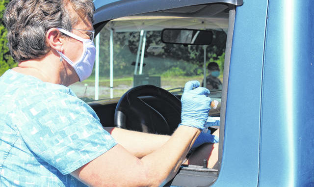 As enfermeiras do Departamento de Saúde do Condado de Anson cumprimentam os pacientes nas janelas de seus carros para dar-lhes vacinas contra a gripe em 30 de setembro. Liz O'Connell | Anson Record