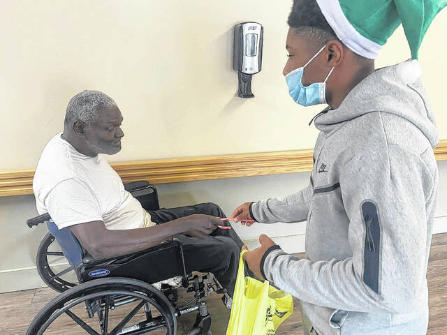 
			
				                                A player passes out a candy cane to a resident.
                                 Contributed photo

			
		